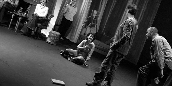Recita teatrale in bianco e nero con cinque attori in scena.