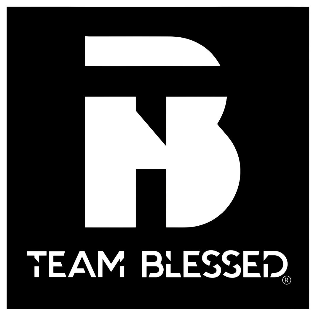 Folded baby clothes with cute animal and nautical prints on a blue wooden surface.