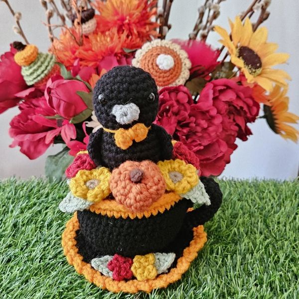 crochet teacup raven with pumpkins, sunflowers, and roses, autumn theme