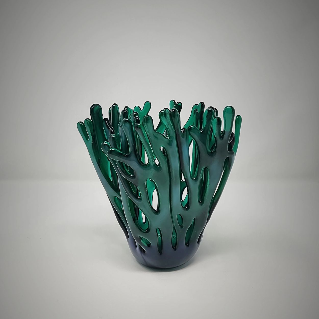 Green glass vase with coral-like design.