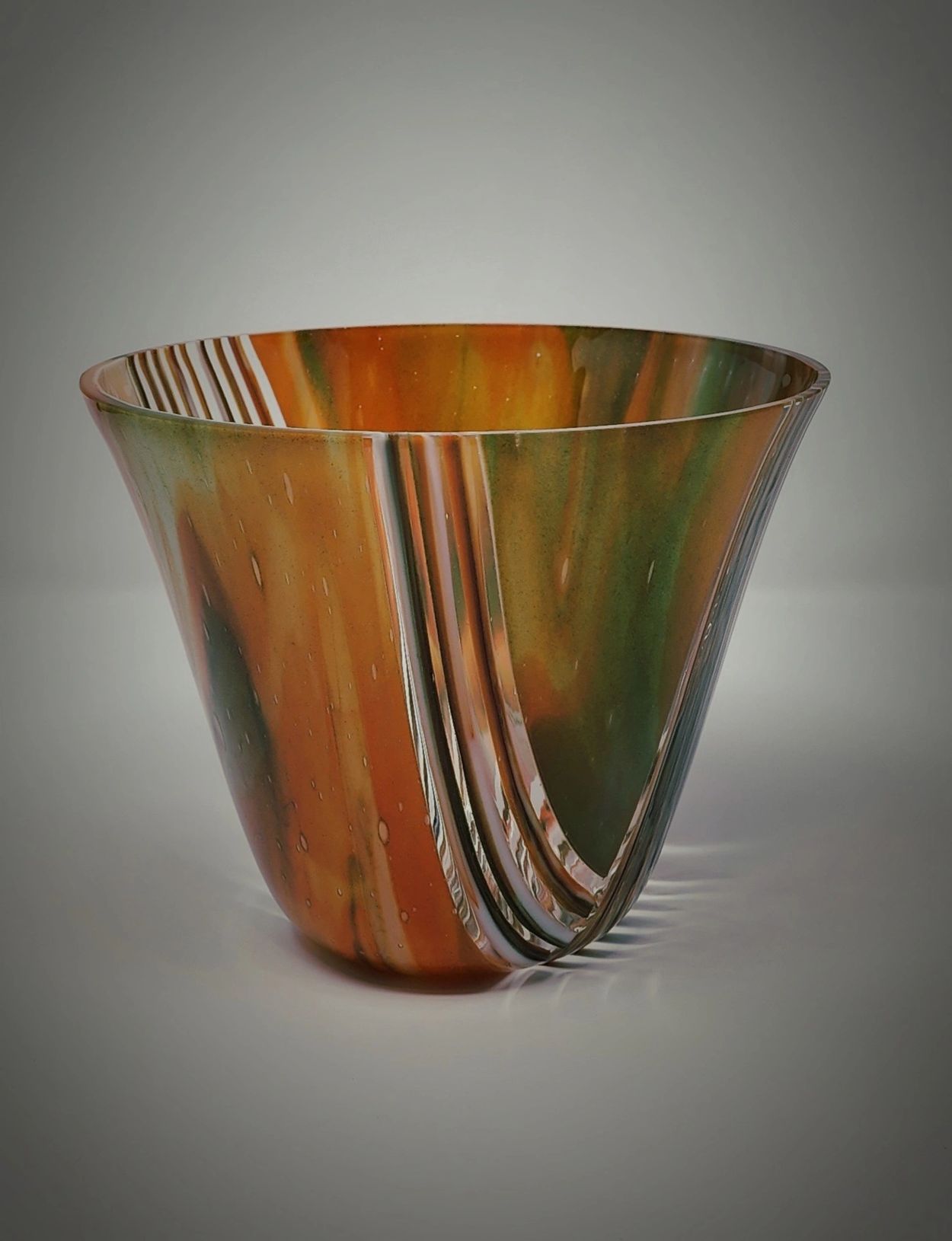 Decorative glass bowl with orange and green swirls.