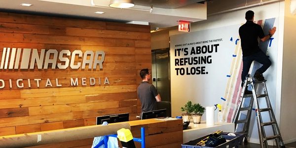 installation in progress at NASCAR Digital Media, dimensional aluminum logo, large format wall vinyl