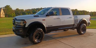 White Ram Power Wagon truck parked on a driveway at sunset.