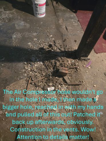 Debris and construction work on a vent with a wooden post shadow.