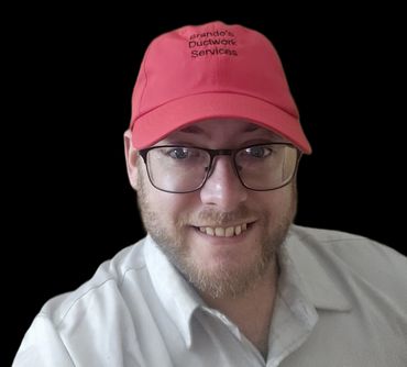 Man wearing glasses and a red cap smiling.