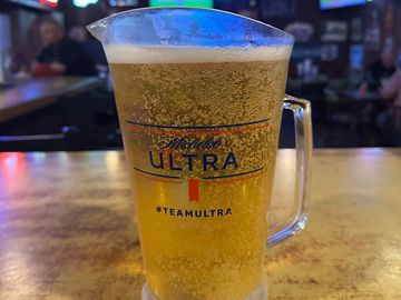 A pitcher of Michelob Ultra beer on a bar counter.