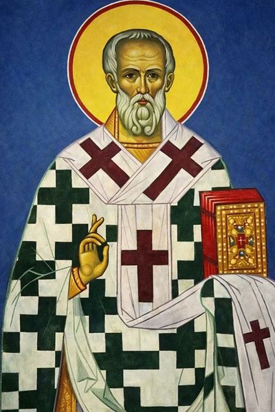 Iconic painting of a saint with a halo and religious attire holding a book.