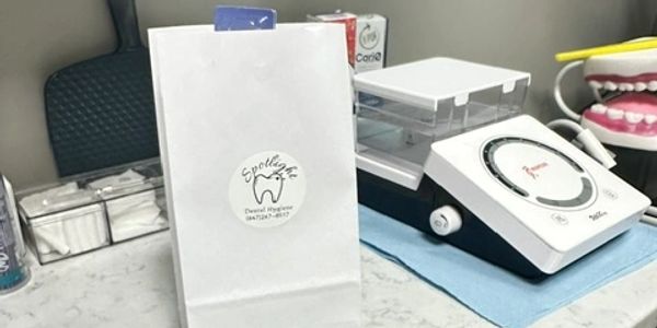 A dental goody bag with the Spotlight Dental Hygiene logo  on the front, on a counter in the hygiene