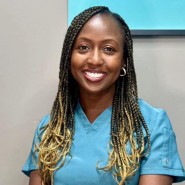 Althea Ledgister RDH, dental hygienist in blue scrubs, smiling at the camera 