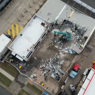 Aerial view of a building demolition site with debris and machinery.