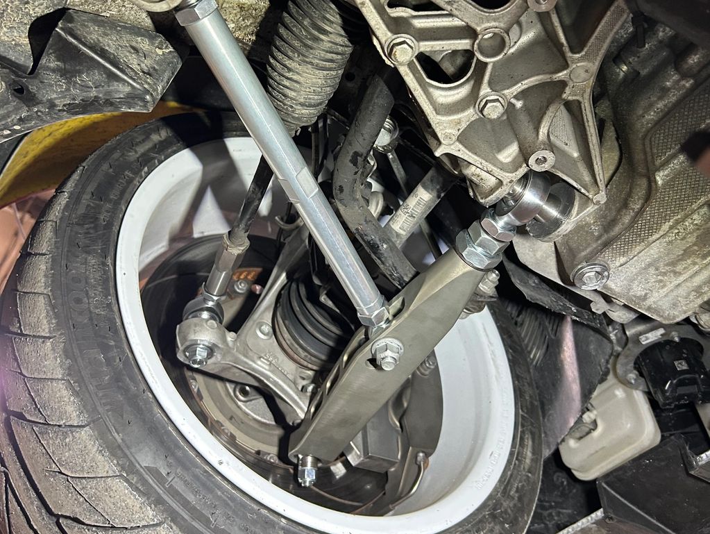 Close-up of a car's suspension and wheel assembly with aftermarket components.