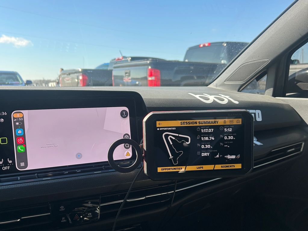 Car dashboard showing navigation and racing session summary screens.