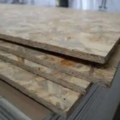 Stack of oriented strand board (OSB) panels used in construction.