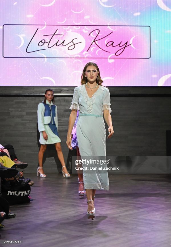 Model walking on runway during Lotus Kay fashion show.