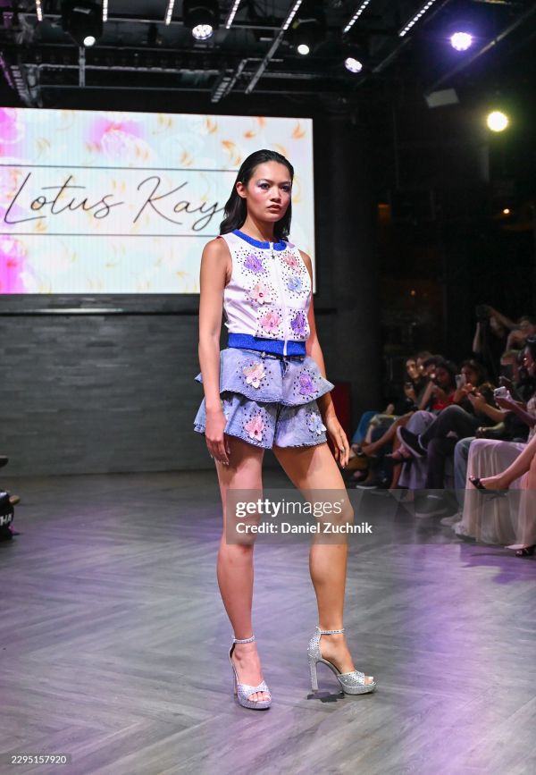 Model walks runway in a floral-themed outfit.