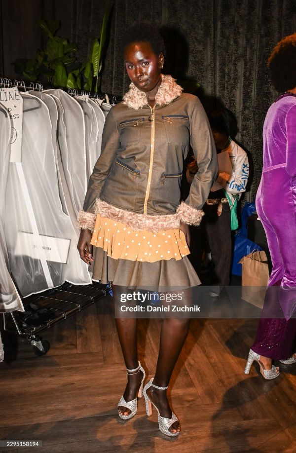 Model posing in a fur-trimmed jacket and polka dot skirt.