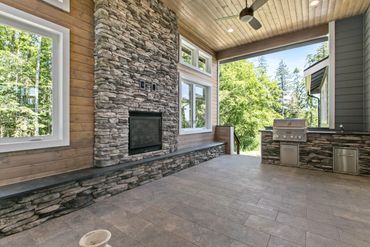 Covered deck with stone fireplace and built in outdoor kitchen.