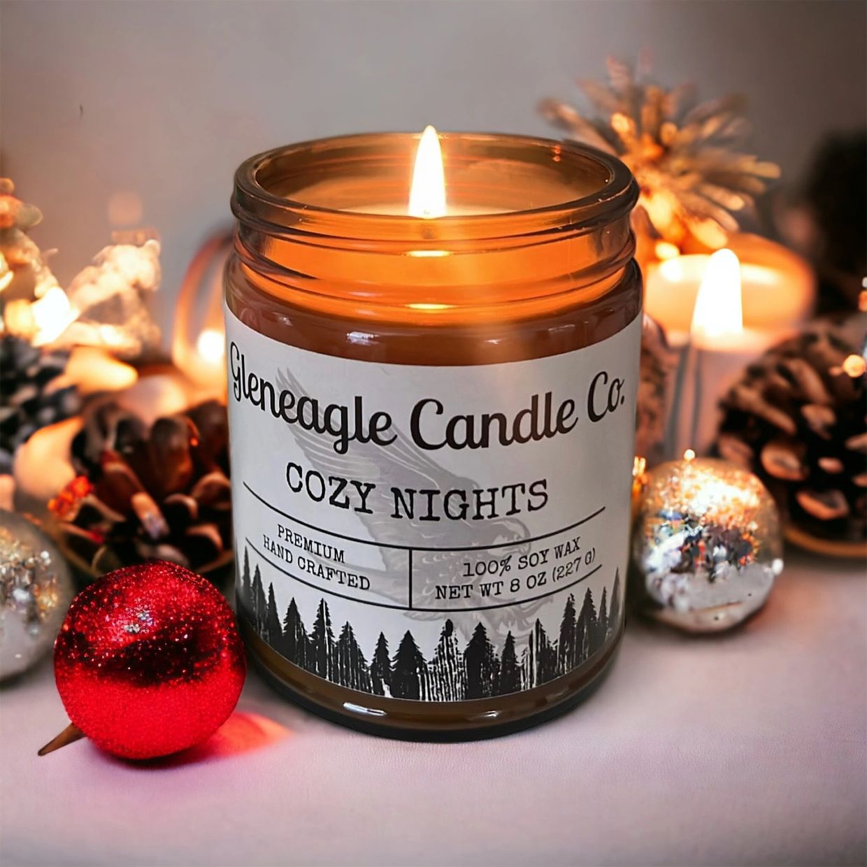 A cozy candle surrounded by holiday ornaments 