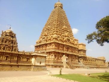 Ancient intricately carved temple tower under clear blue sky.