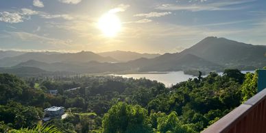 Scenic sunset over a mountainous landscape with a lake.