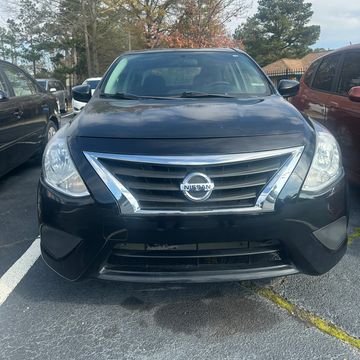 Front view of a black Nissan car parked outdoors.