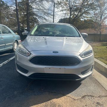 Front view of a silver Ford parked in a lot on a sunny day.