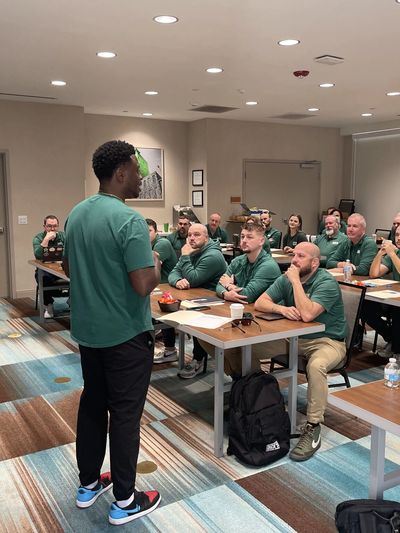 Motivational speaker leading a high-impact leadership session for engaged professional team.
