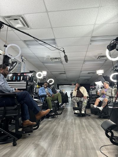 Live podcast-style discussion with diverse leaders in a shop setting, filmed for audience engagement