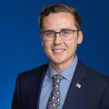 Professional leader in suit with flag pin against blue backdrop