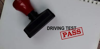 A stamp showing PASS on a driving test paper.