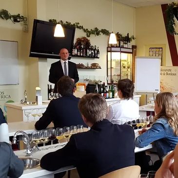 A sommelier leads a wine tasting session for attentive participants.