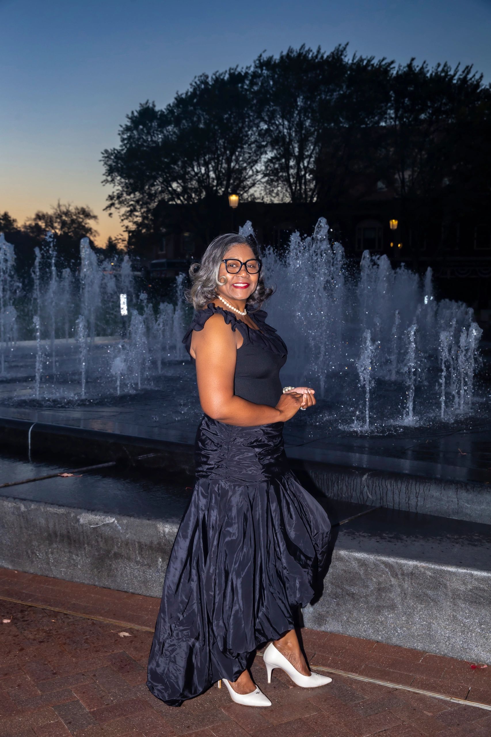 a woman in a black dress looks at the camera