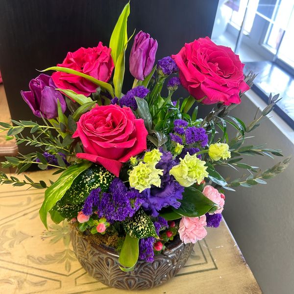 Dish garden with fresh flowers including roses, tulips, lisianthus, parvifolia eucalyptus, hypericum