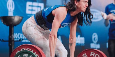 Woman lifting a heavy barbell in a weightlifting competition.