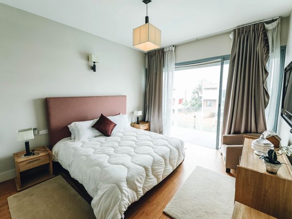 A bedroom with nightstands, and a big window