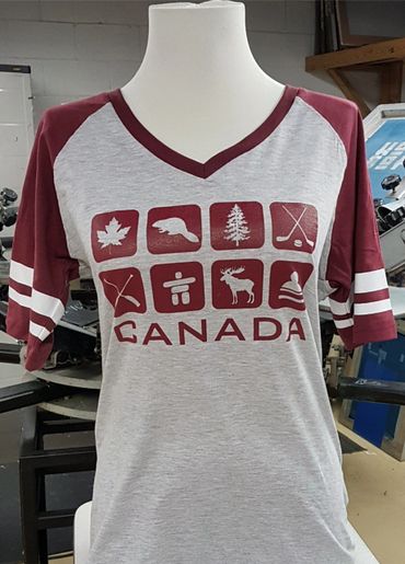 Grey and maroon Canada-themed t-shirt with iconic Canadian symbols.