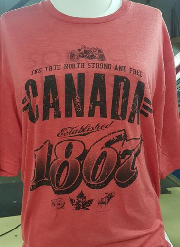 Red t-shirt with vintage Canada 1867 print and iconic symbols.