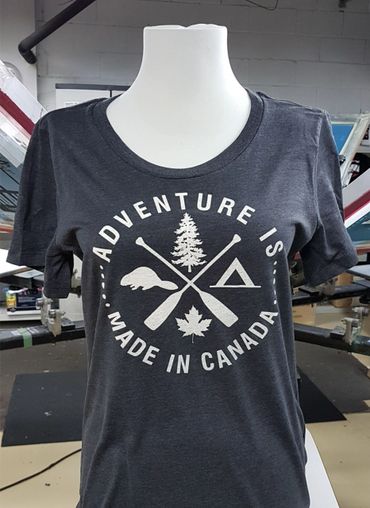 Dark grey t-shirt with Canadian adventure-themed white print design.