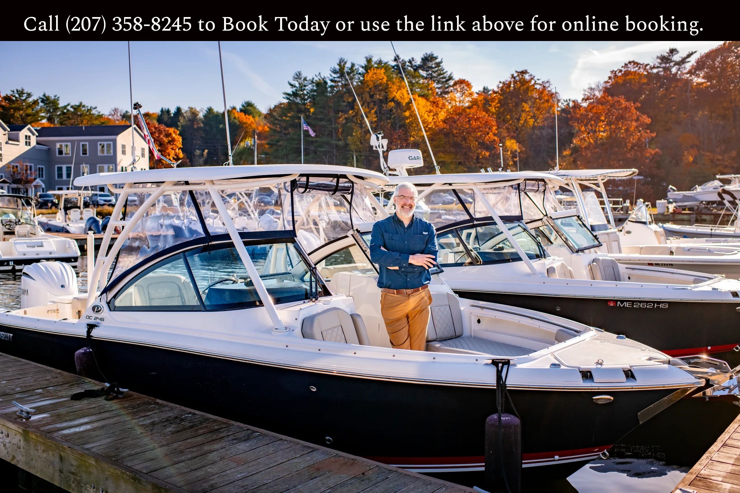 Man standing on a boat docked at a marina during autumn.