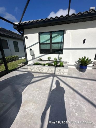 Backyard patio with raised garden bed and potted plant.