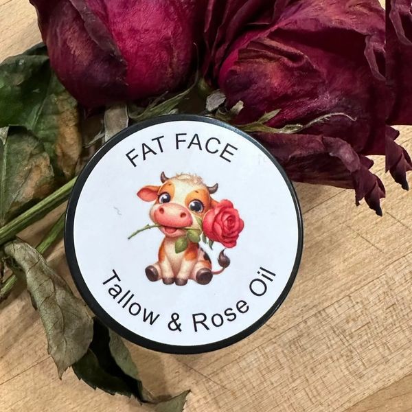 Container of Fat Face Tallow & Rose Oil with dried red roses.