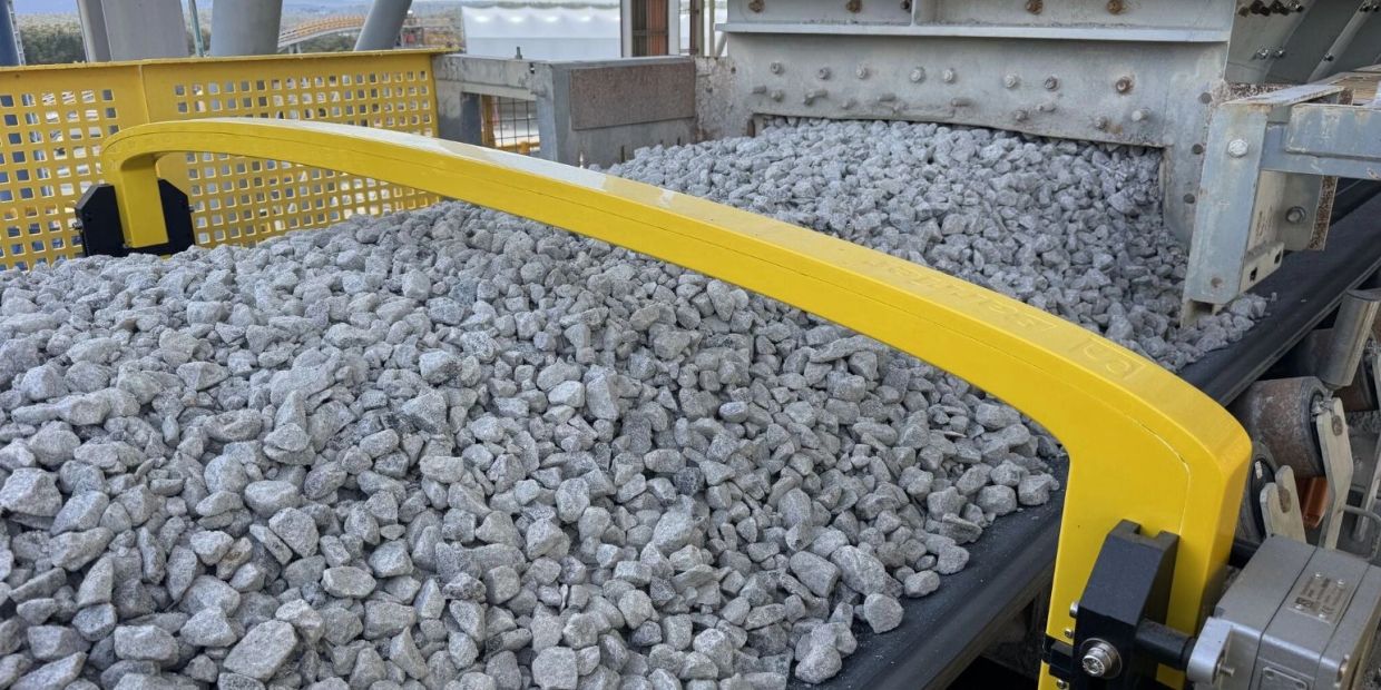 Barrier tramp metal detector installed on a mining conveyor for tramp metal detection and crusher protection.