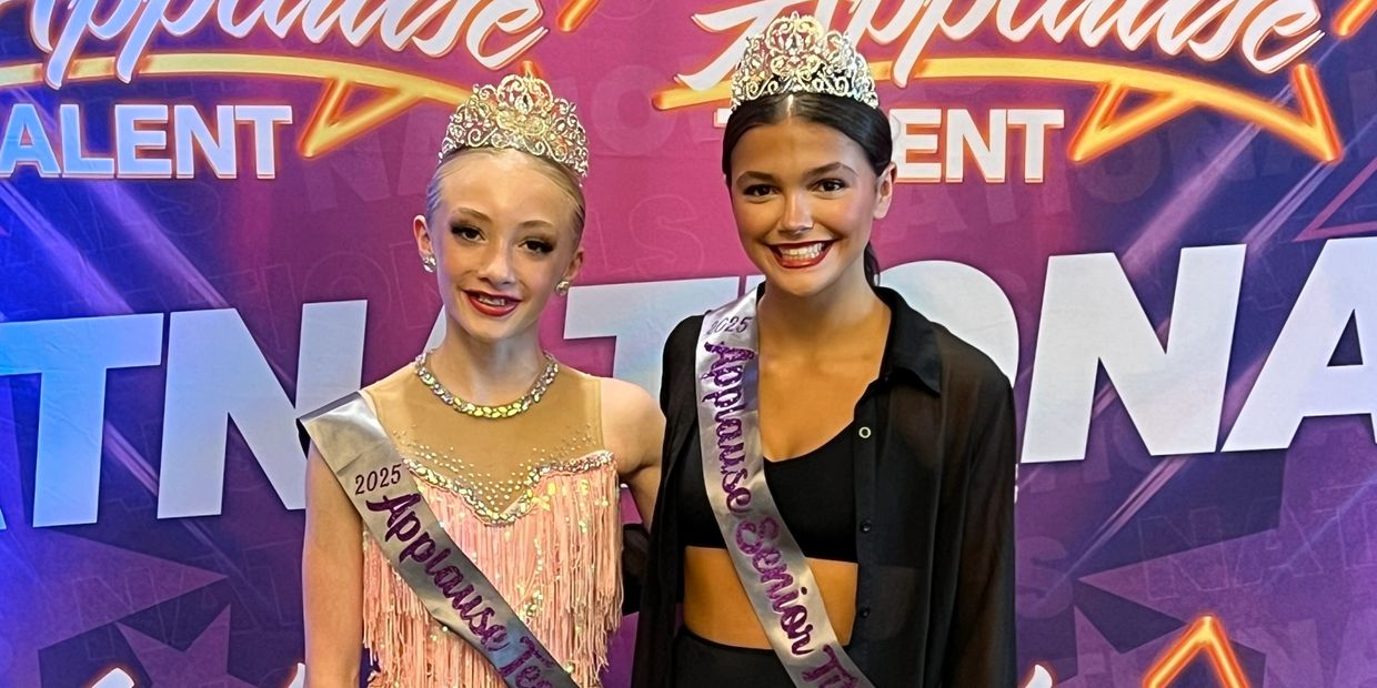 Two young pageant winners wearing crowns and sashes at a talent event.