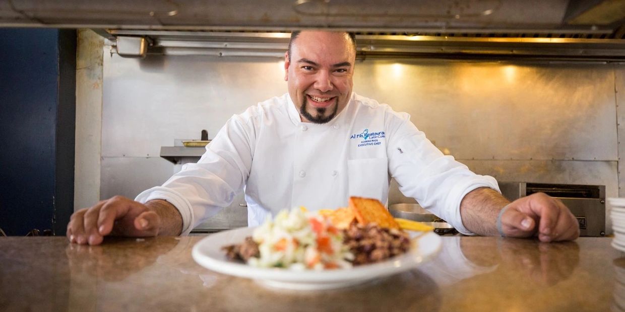 Chef smiling with delicious dish in front