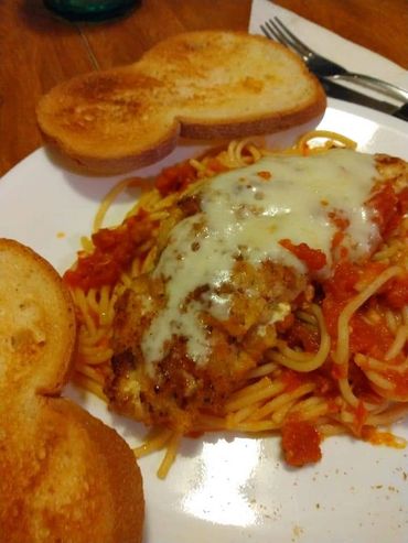 A plate of pasta and two pieces of bread