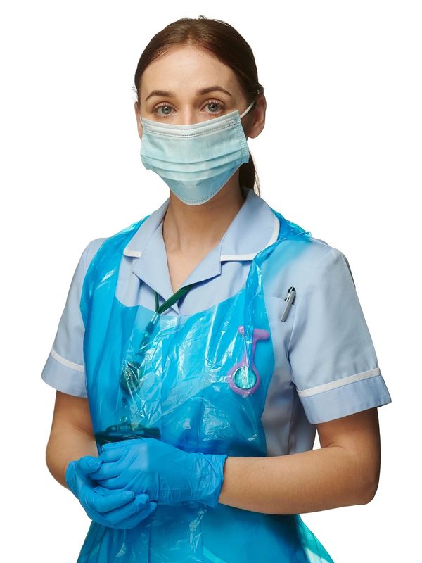 Healthcare worker wearing PPE including apron, gloves, and face mask for infection control.