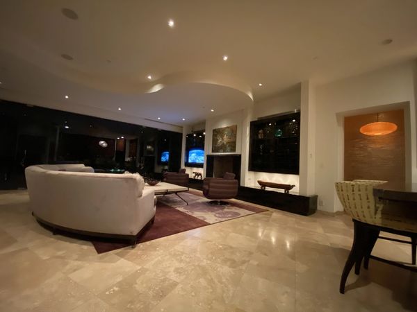 Luxurious modern living room with curved white sofa and ambient lighting.
