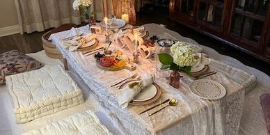 Elegant low table dinner setup with cushions.