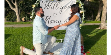 Man proposing to woman in a park.