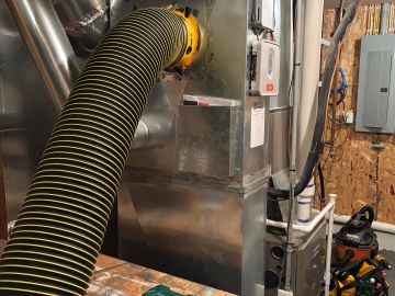 Flexible duct connected to HVAC system in a basement.